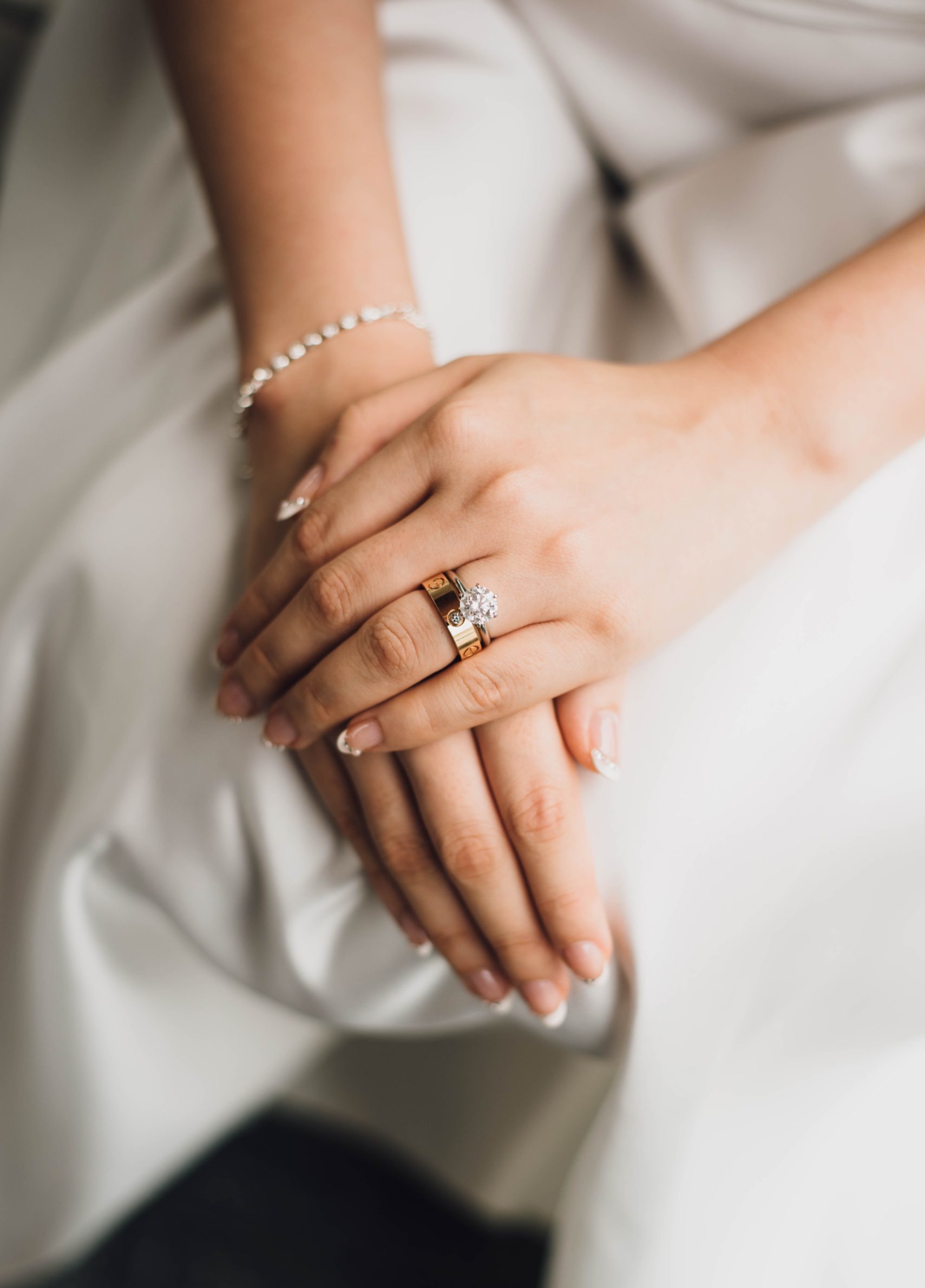 Brudeparets hender, tett sammen med bryllupsringer og elegant smykker.